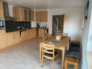 a kitchen with a wooden table and chairs in it at Ferienhaus-Zirndorf in Zirndorf