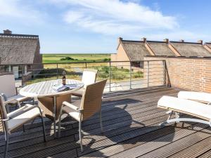 a patio with a table and chairs on a deck at Apartment Helgo - 250m from the sea in Western Jutland by Interhome in Sønderby