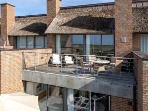 a balcony with chairs and tables on a brick building at Apartment Helgo - 250m from the sea in Western Jutland by Interhome in Sønderby