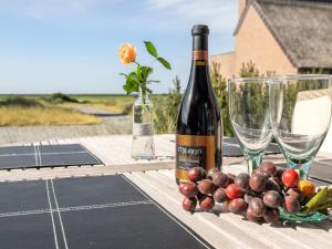 a bottle of wine and grapes on a table at Apartment Helgo - 250m from the sea in Western Jutland by Interhome in Sønderby