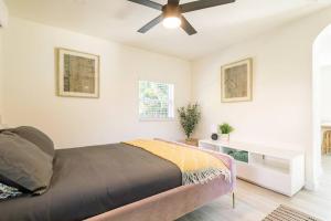 The Pastel Home في فورت لاودردال: غرفة نوم بسرير ومروحة سقف