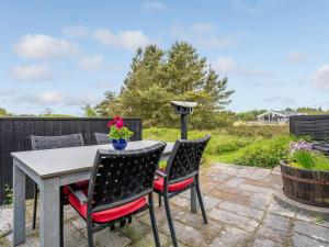 a patio with a table and four chairs at Holiday Home Kathaline - 3-4km from the sea in Western Jutland by Interhome in Bolilmark