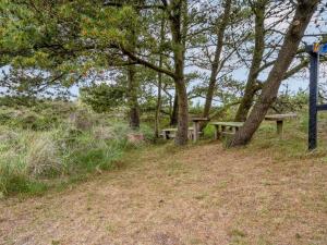 a picnic bench sitting on a hill next to trees at Holiday Home Kathaline - 3-4km from the sea in Western Jutland by Interhome in Bolilmark