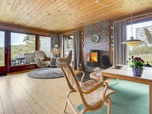 a living room with a table and chairs and a fireplace at Holiday Home Kathaline - 3-4km from the sea in Western Jutland by Interhome in Bolilmark