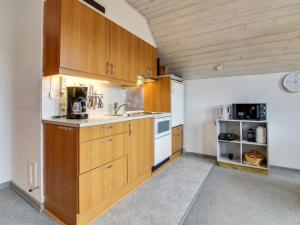 una cocina con armarios de madera y fregadero en Apartment Tuve - 2-5km from the sea in Western Jutland by Interhome, en Sønderby