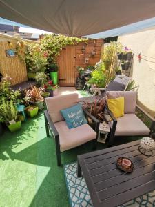 une terrasse avec 2 chaises, une table et des plantes dans l'établissement Maison Acacias Le Mans, au Mans