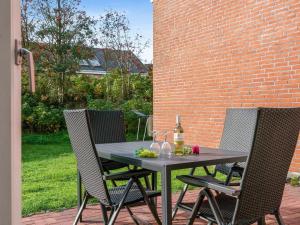 - une table avec 2 chaises et une bouteille de vin dans l'établissement Apartment Palni - 2-3km from the sea in Western Jutland by Interhome, à Sønderby