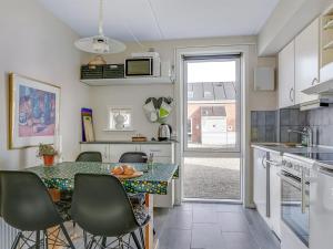 une cuisine avec une table et des chaises et une cuisine avec une fenêtre dans l'établissement Apartment Palni - 2-3km from the sea in Western Jutland by Interhome, à Sønderby
