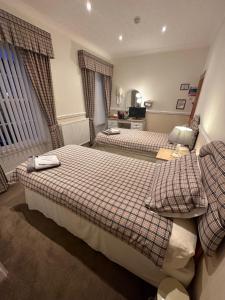 a hotel room with two beds and a chair at Vane House in Osmotherley