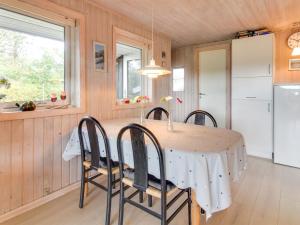 eine Küche und ein Esszimmer mit einem Tisch und Stühlen in der Unterkunft Holiday Home Tuulikki - 1-6km from the sea in Western Jutland by Interhome in Vejers Strand