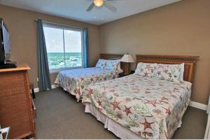 a bedroom with two beds and a large window at San Carlos 701 in Gulf Shores