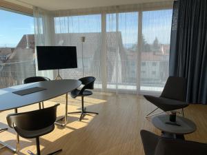 a room with a table and chairs and a large window at Trilogie am See Wohnung Taube in Stetten