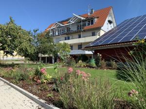 a house with solar panels on top of a garden at Trilogie am See Wohnung Taube in Stetten