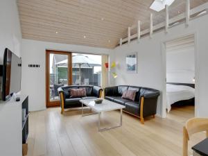 a living room with a couch and a table and a bed at Apartment Elara - 200m from the sea by Interhome in Lakolk +23 photos