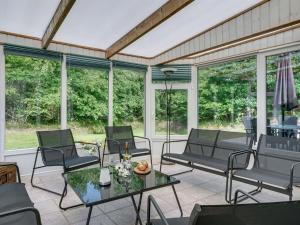 VesterhedeにあるHoliday Home Gwen - 2-7km from the sea by Interhomeの椅子とテーブルの付いたポーチ