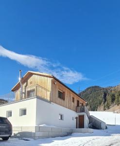 ein weißes Gebäude mit Balkon darüber in der Unterkunft Bergblick Vadiesen in Pettneu am Arlberg