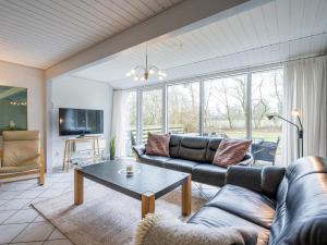 a living room with a couch and a table at Holiday home Oksbøl LVII in Oksbøl