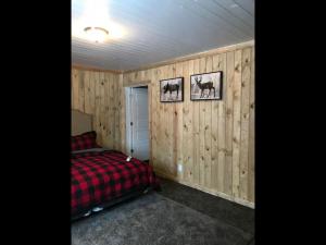 a bedroom with wood paneled walls and a bed at Family Cabin Unit 7 in Rea