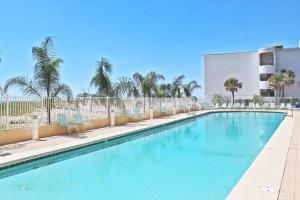 a large swimming pool with chairs and a building at San Carlos 801 in Gulf Shores