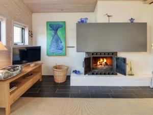 sala de estar con chimenea y TV en Holiday Home Pisana - 400m from the sea in Western Jutland by Interhome, en Vejers Strand