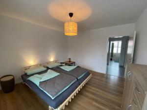 - une chambre avec un lit et un lustre dans l'établissement Apartment II Am Jakobsweg, à Erfurt