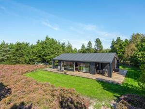 a modular house with a black roof on a hill at Holiday Home Tea - 2-7km from the sea in Western Jutland by Interhome in Bolilmark