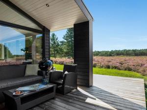 a patio with a couch and chairs on a wooden deck at Holiday Home Tea - 2-7km from the sea in Western Jutland by Interhome in Bolilmark