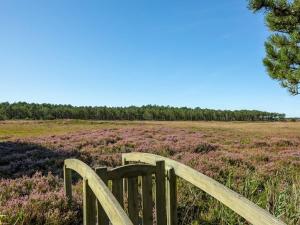 a wooden bench in a field with purple flowers at Holiday Home Tea - 2-7km from the sea in Western Jutland by Interhome in Bolilmark