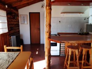 cocina con encimera y taburetes en una habitación en Cabaña Pampa en Esquel
