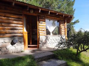 a log cabin with a door and a window at Cabaña Pampa in Esquel