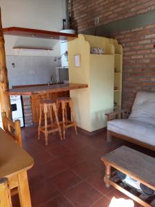 sala de estar con cocina, mesa y sillas en Cabaña Pampa en Esquel