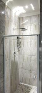 a shower with a glass door in a bathroom at Cheers in Evander
