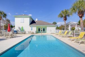 a swimming pool with chairs and a house at Orange Beach Villas - Casa Bella in Orange Beach