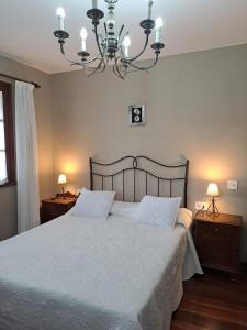 a bedroom with a large bed with a chandelier at Hostal Boavista in Costoia