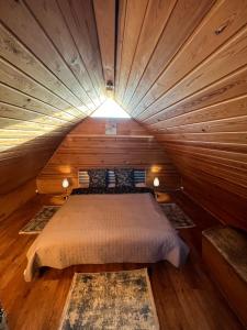 een slaapkamer met een bed in een houten kamer bij Pirtiņa in Ogre