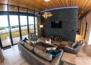 sala de estar con sofá, sillas y TV en Goosedale Lodges en Nottingham