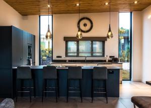 a kitchen with a large island with bar chairs at Goosedale Lodges in Nottingham