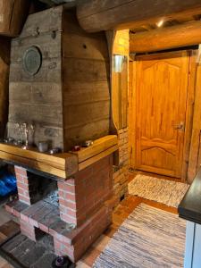 Habitación de madera con chimenea y puerta de madera en Pirtiņa en Ogre