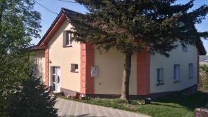 a small house with a tree in front of it at Agrowilla Kozłówek in Kozłówek