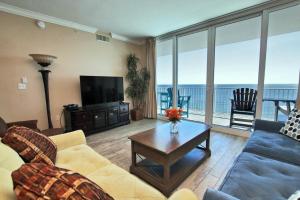 een woonkamer met een bank, een tv en een tafel bij San Carlos 1706 in Gulf Shores