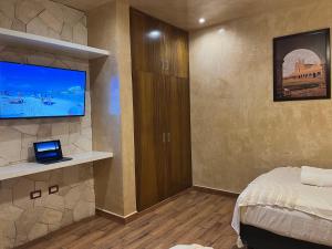 a bedroom with a bed and a flat screen tv at New apartment with all services and pool Marcos #1 in Isla Mujeres