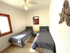 1 dormitorio con 2 camas y ventana en Villa Secreto, en Peñíscola 7 fotos más
