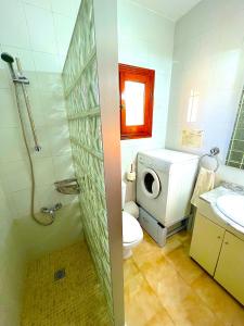 y baño con lavamanos y lavadora. en Villa Secreto, en Peñíscola