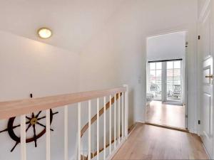 a white hallway with a staircase in a house at Apartment Guthir - 1-2km from the sea in Western Jutland by Interhome in Blåvand