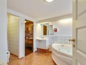 a bathroom with a tub and a sink at Apartment Guthir - 1-2km from the sea in Western Jutland by Interhome in Blåvand