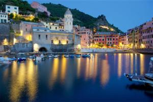 a city with boats in the water at night at Il Nido di Marco a due passi dal mare in Portovenere