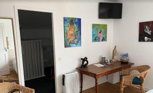 Habitación con escritorio y algunas pinturas en la pared. en Haritza, en Anglet