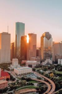 een skyline van de stad met wolkenkrabbers bij zonsondergang bij Modern Urban Oasis with Private Parking in Downtown Houston in Houston