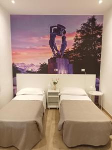 2 Betten in einem Zimmer mit Wandgemälde in der Unterkunft Hotel Porta Rivera in LʼAquila