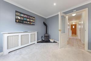 Flourish Apartments - Footbury House - Orpington في أوربنغتون: غرفة معيشة مع موقد وتلفزيون على الحائط